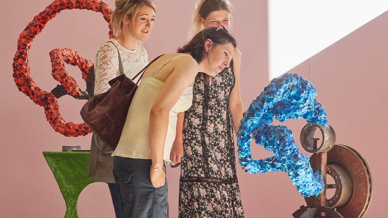 Visitors with Lester Korzilius' work at the Angel Cake preview. Photo by Barney Hindle. 