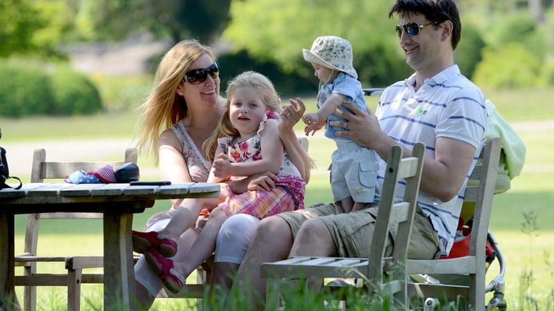 A family relaxing at West Dean Gardens