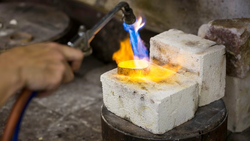 Close-up of a flame heating a piece of metal on a jewellery course. Photo by Chris Ison