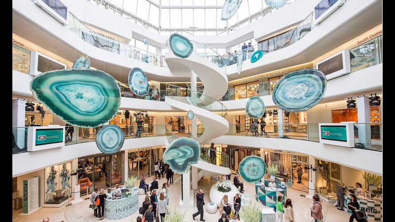 A view looking up in modern circular atrium at KLC School of Design, higher floors are visible with a hanging installation in the centre.