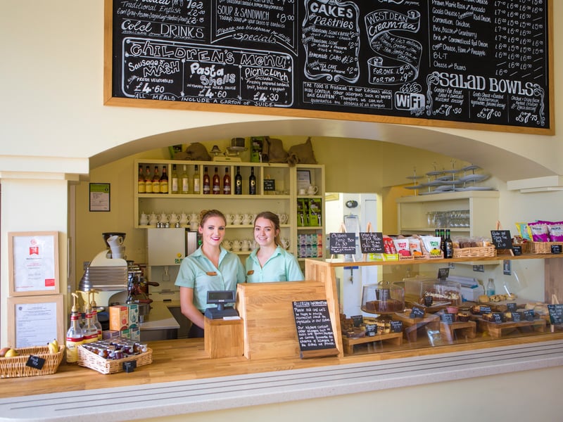 Two West Dean Gardens Restaurant staff standing at the till