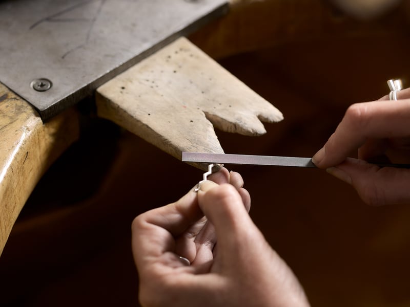 Silversmith filing metal for jewellery