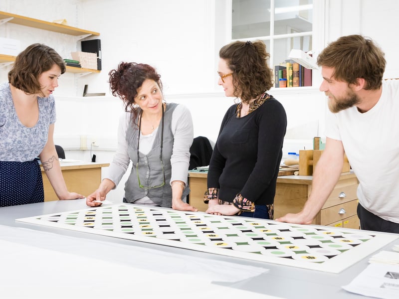Mariluz Beltran de Guevara discussing the treatment of a sample of Edward James' 'Turtle' wallpaper with her students.