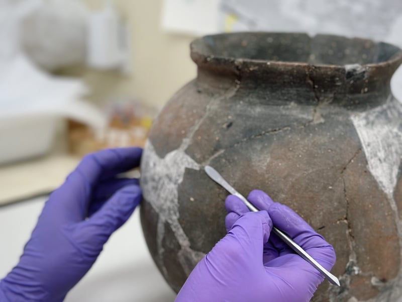 Ceramic student working on an archaeological pot 