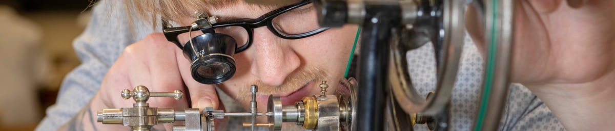 Conservation of clocks student in the horology workshop at West Dean College