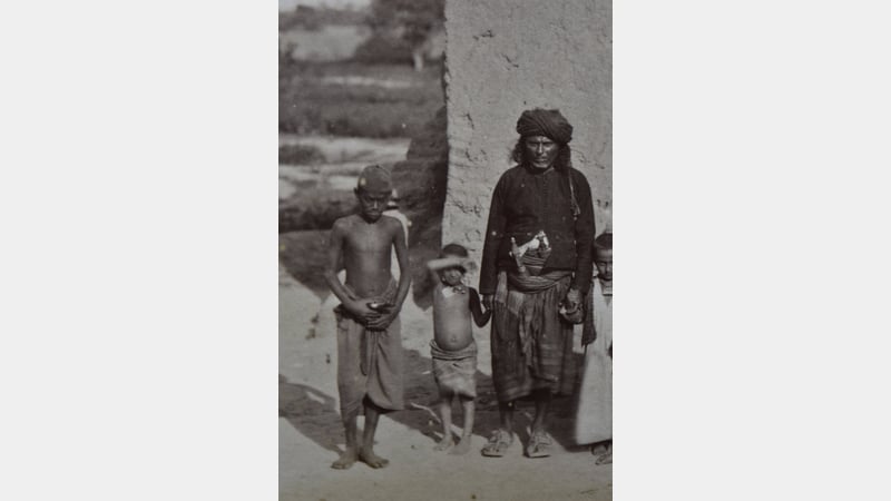 Detail of image, shows man and older boy with khanjar, young boy without, indicating the age where boys are viewed as becoming men